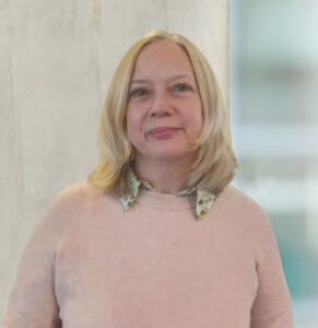 Headshot of Clare Emery wearing a pink jumper.