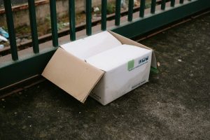 a box sitting on the ground next to a fence